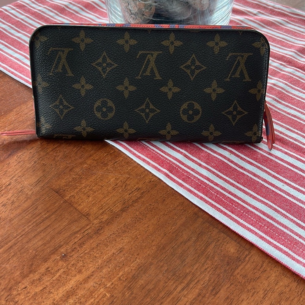 Louis Vuitton Insolite monogram wallet with coral and blue interior.